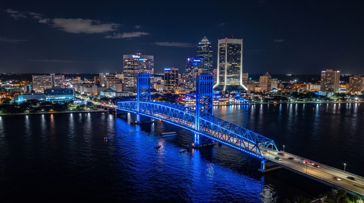 Jacksonville's iconic Main Street Bridge—affectionately known as the "Blue Bridge"—glows in vibrant blue against the night sky above the St. Johns River, one of seven highway crossings connecting the River City.