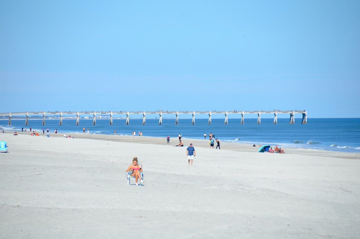 Beachgoers near the Jacksonville Beach fishing pier in December 2025.