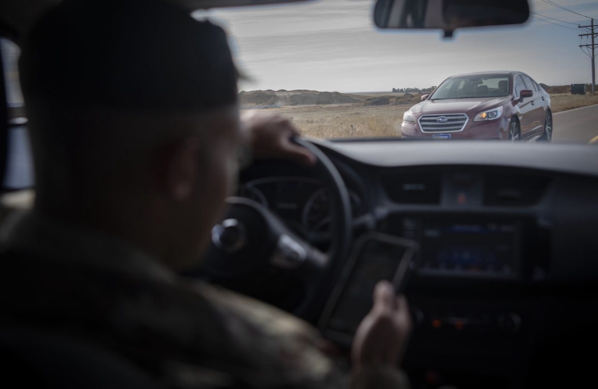 A driver looks at a phone while driving (U.S. Space Force photo).