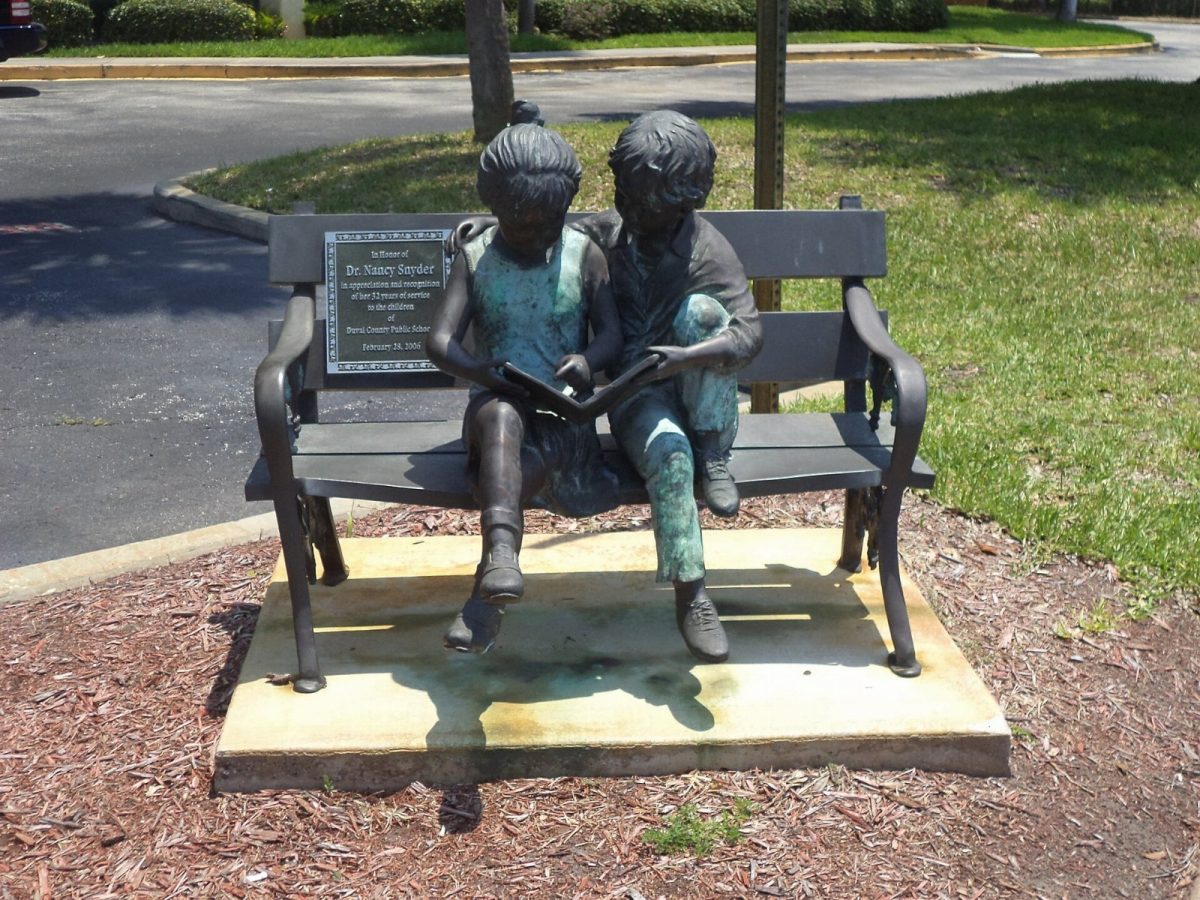 A sculpture of two children reading, outside the Duval County Public Schools headquarters.