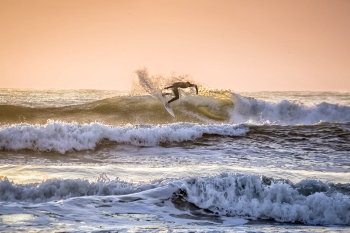 A surfer rides a wave at sunrise near the Jacksonville Beach Pier (file photo).