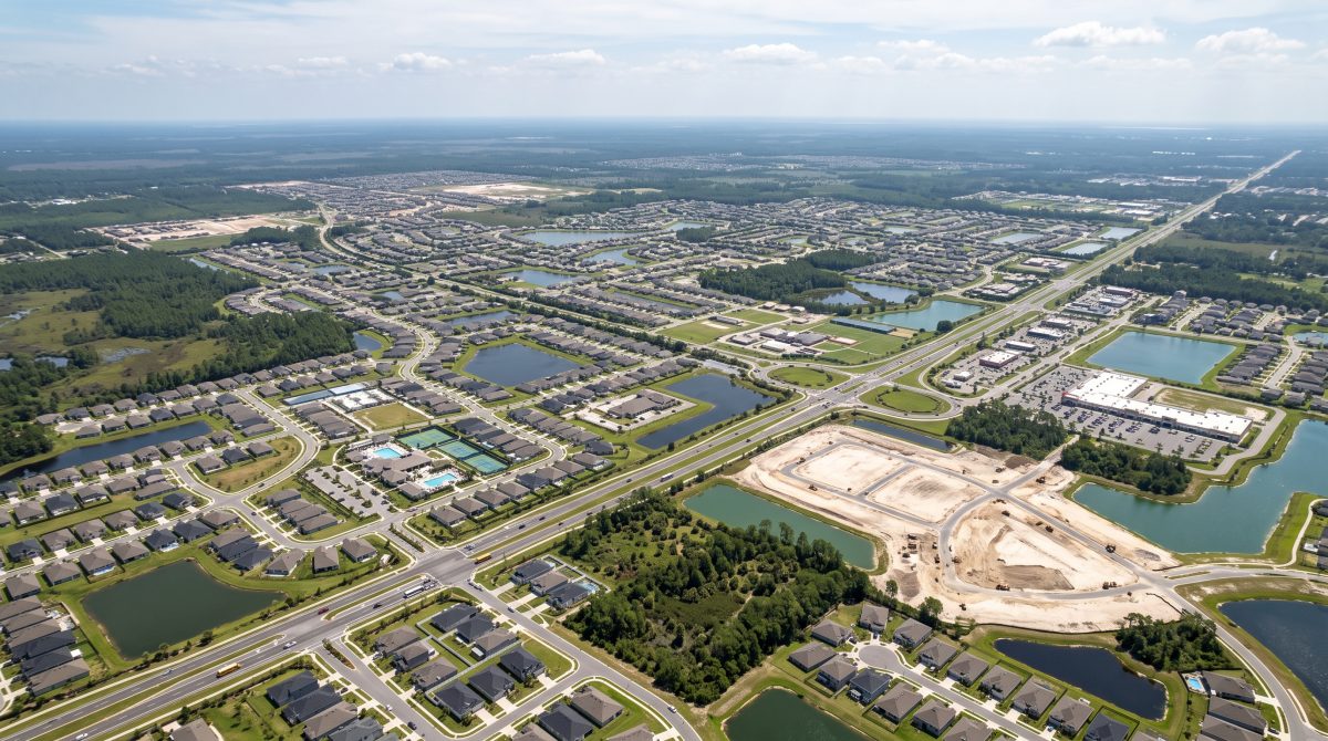 An aerial view shows sprawling new housing developments and active construction sites expanding across St. Johns County, reflecting its rapid population growth.