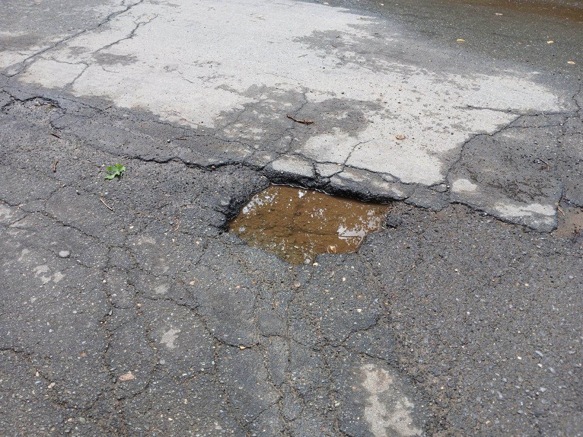 A water-filled pothole in cracked asphalt (file photo).