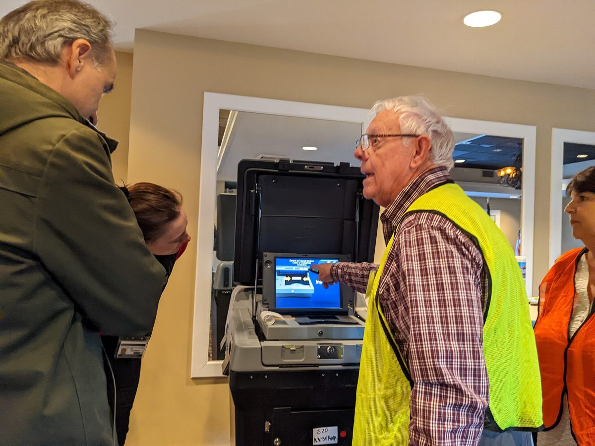 A poll worker demonstrates voting equipment at a polling place in 2022 (file photo, Virginia).